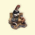 Figura de Porcelana Valenciana Nalda: madre amamantando a su bebé en un banco con niño pequeño al lado, decoración artesanal emotiva.