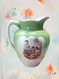 Jarra de aguamanil Cartuja de Sevilla vintage en porcelana con ilustración de niños jugando, perfecta para decoración nostálgica y coleccionistas.