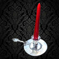 Palmatoria de Época en alpaca con vela roja sobre fondo barroco, ideal para añadir encanto vintage a tu hogar en decoración clásica.