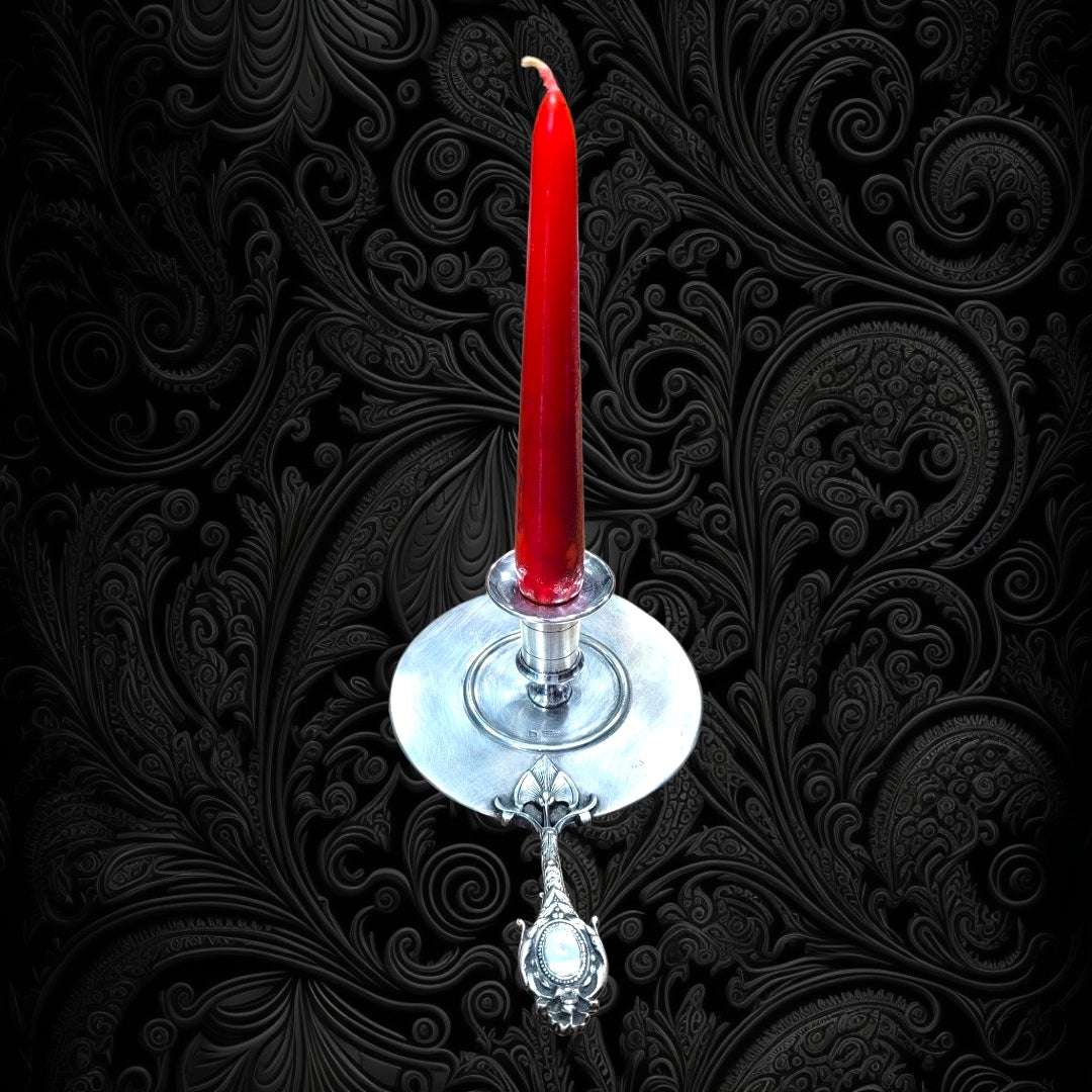 Decoración vintage con Palmatoria de Época fabricada en Meneses, con vela roja y detalles ornamentales, perfecta para iluminar con estilo.