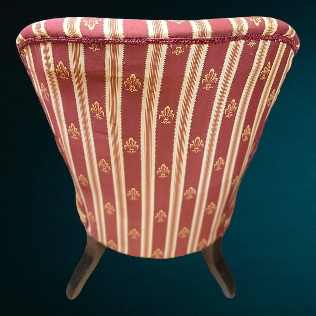 Respaldo trasero de butaca de caoba de época con tapizado a rayas burdeos y detalles dorados, ideal para ambientes elegantes y clásicos.