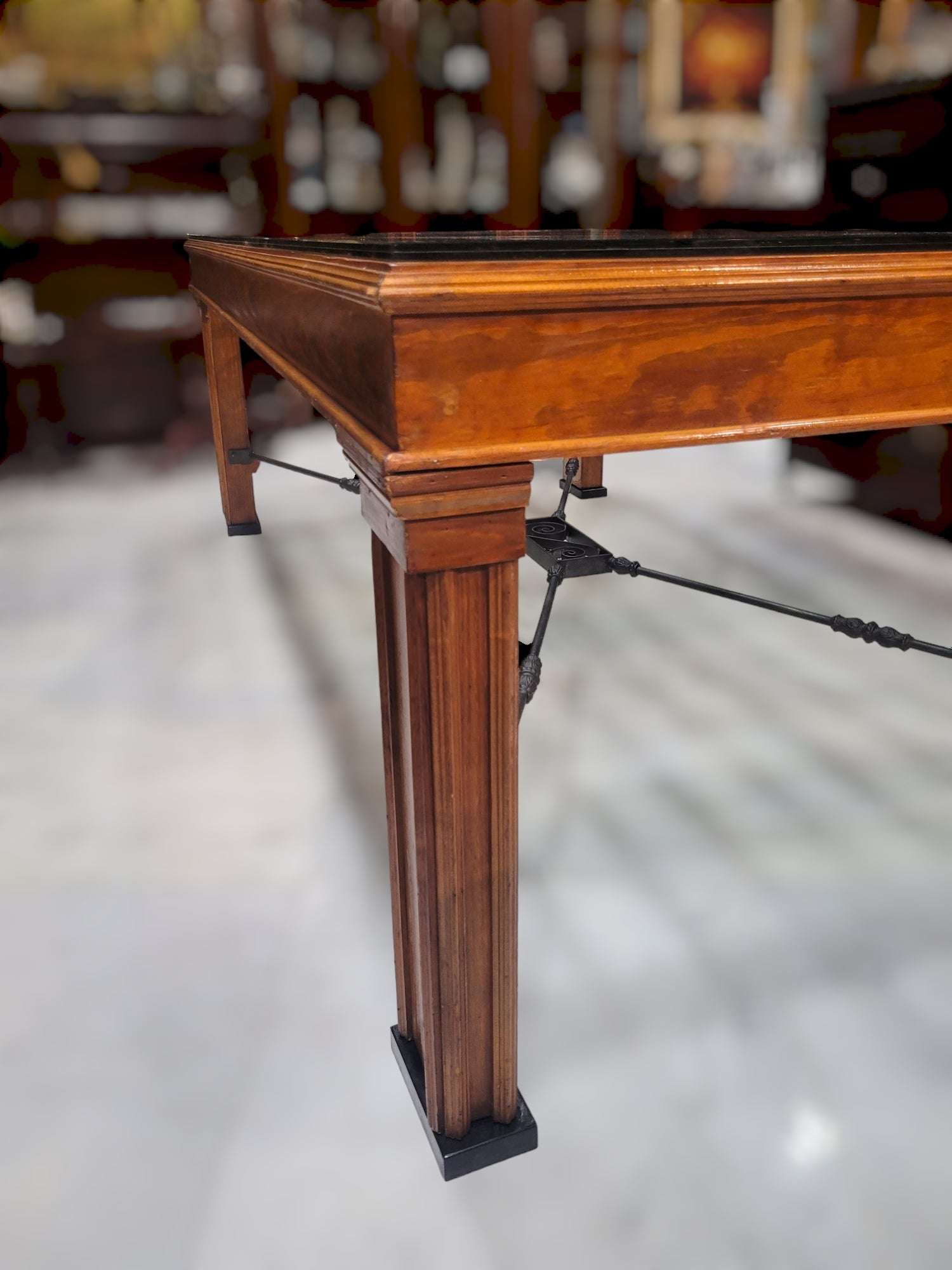 Detalle de la pata de la Mesa Reja Comedor con acabado en madera y refuerzos metálicos, perfecta para espacios decorativos sofisticados.