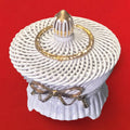 Joyero artesanal de porcelana blanca con detalles dorados y diseño trenzado, perfecto para almacenar joyas con estilo en espacios decorativos.