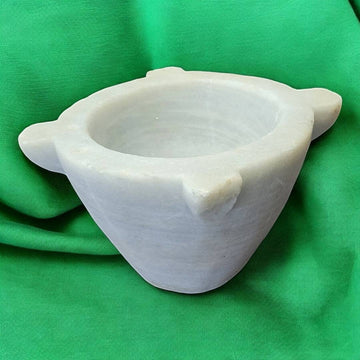 Mortero de mármol antiguo y auténtico de Cositas Antiguas, ideal para decoración de cocina o farmacia, sobre fondo verde.