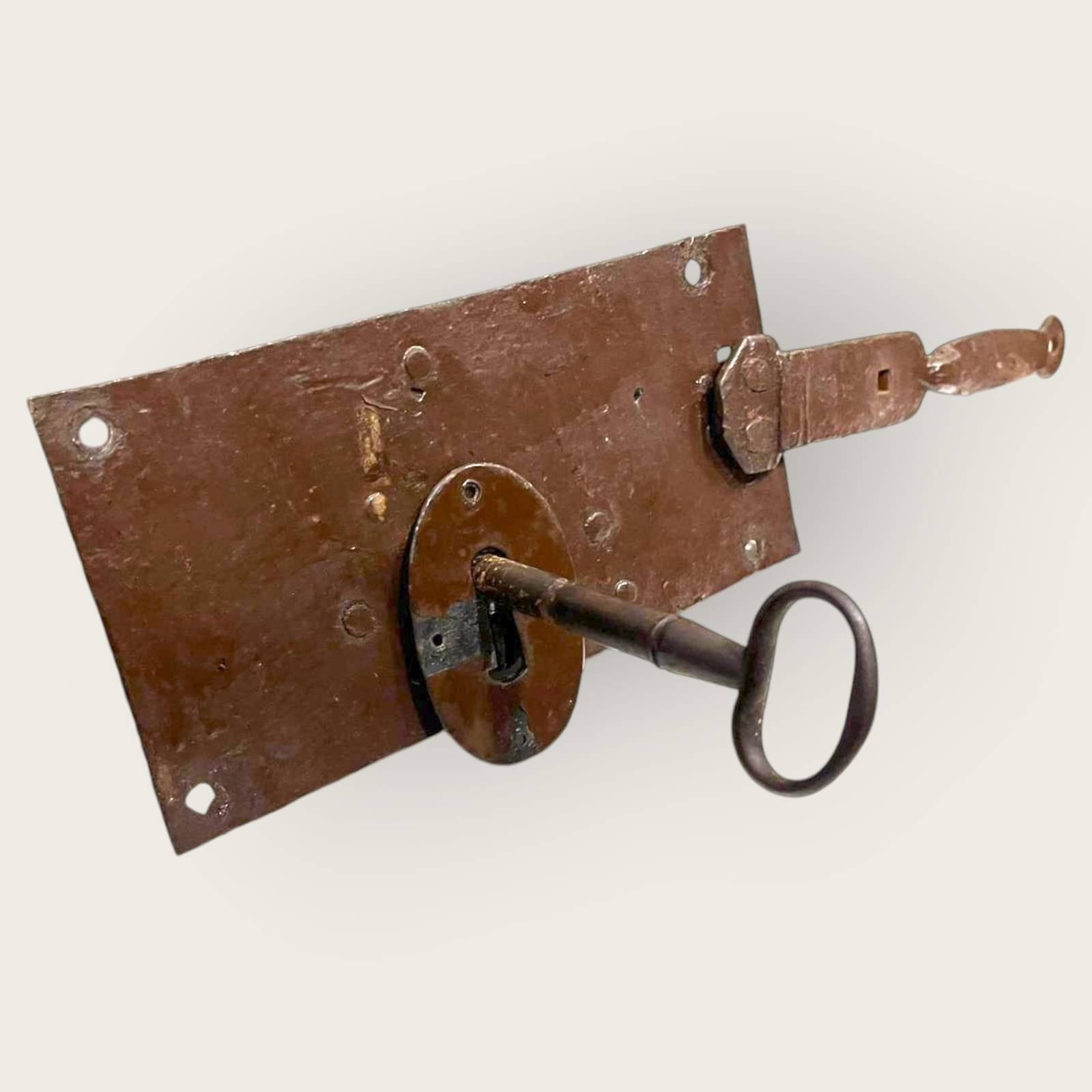 Cerradura antigua de hierro con llave insertada, perfecta para añadir encanto rústico y seguridad a portones decorativos.
