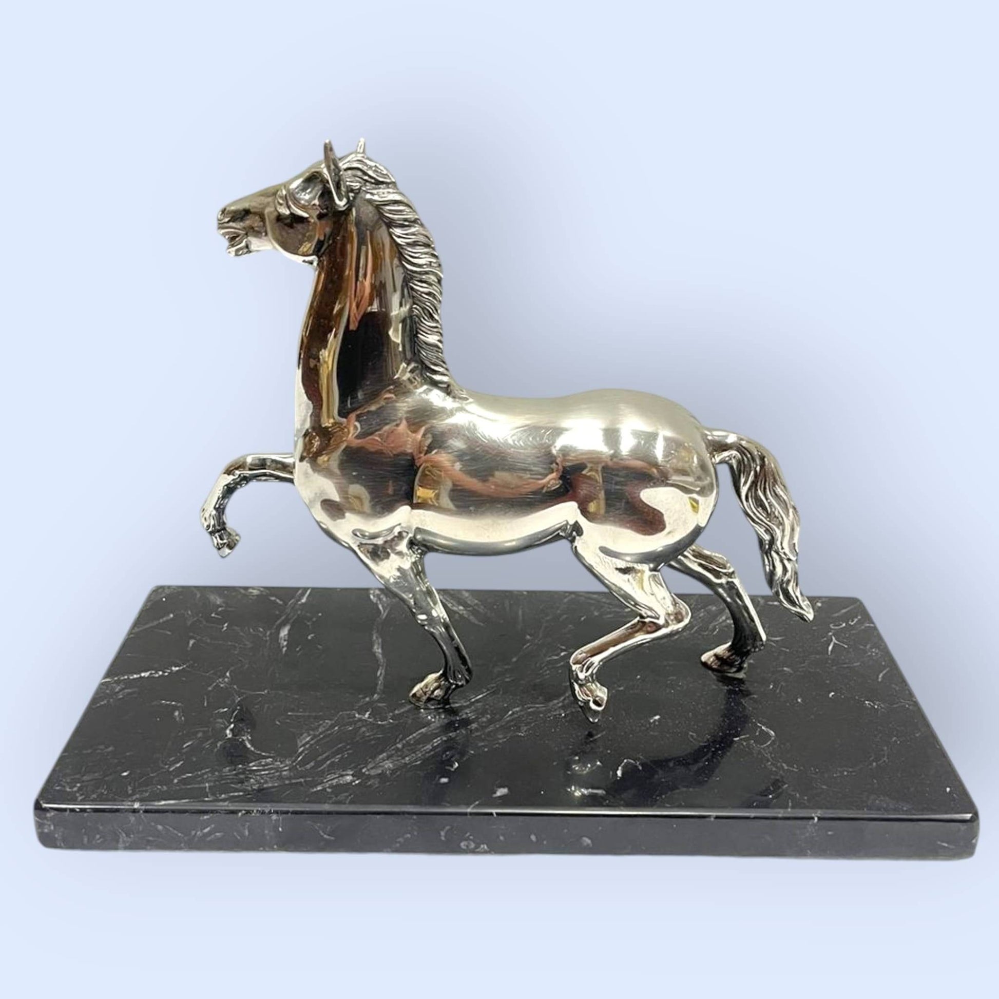 Figura decorativa de caballo en plata con base de mármol negro. Añade lujo y estilo clásico a cualquier espacio del hogar.