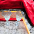 Vista superior de copas de cristal de Bohemia vintage, juego de 2 elegantes con diseño tallado, sobre fondo de mármol y terciopelo rojo.