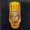 Copa decorativa de cristal color ámbar con figura de Don Quijote en plata auténtica, perfecta para coleccionistas y amantes del arte clásico.