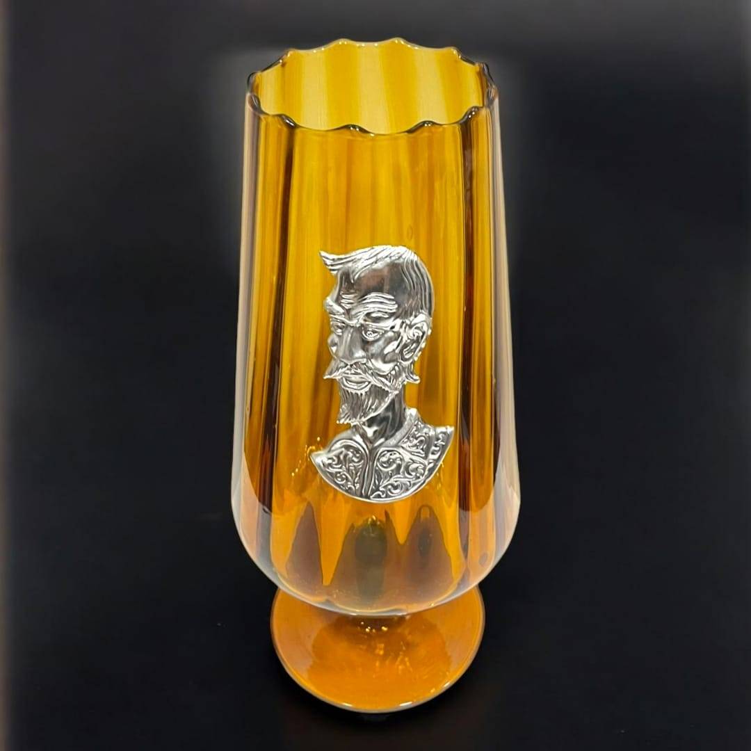 Copa decorativa de cristal color ámbar con figura de Don Quijote en plata auténtica, perfecta para coleccionistas y amantes del arte clásico.