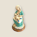 Figura de madre e hijo en acto de lactancia, representación artística de vínculo maternal, perfecta para decoración temática de hogar.