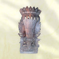 Vista trasera de la estatua Nepali de Bhairava en madera, mostrando el trabajo artesanal y la forma tallada del tocado tradicional.