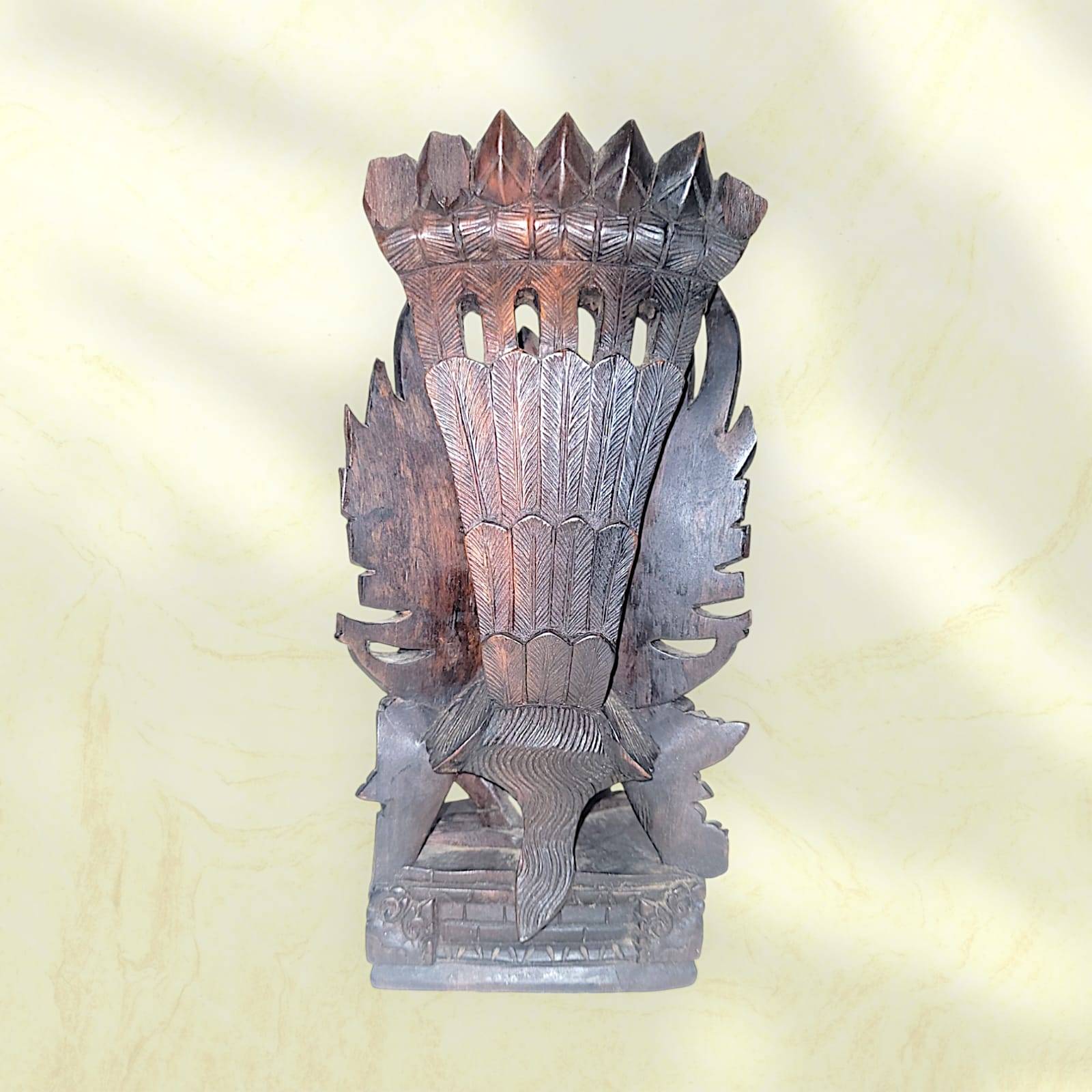 Vista trasera de la estatua Nepali de Bhairava en madera, mostrando el trabajo artesanal y la forma tallada del tocado tradicional.