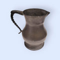 Jarra de peltre de estaño con diseño clásico y asa ornamentada, ideal para decoración vintage en hogar y jardín. Disponible en limbaproecher.com.