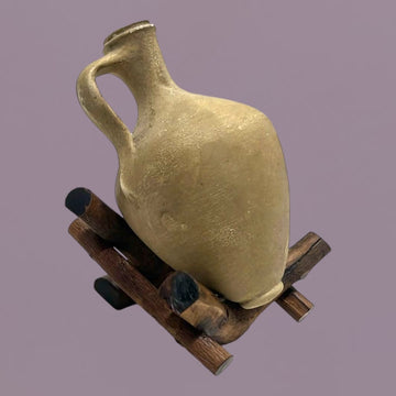 Cántara miniatura de Lebrija sobre soporte de madera rústica, ideal para decoraciones auténticas en espacios tradicionales del hogar.