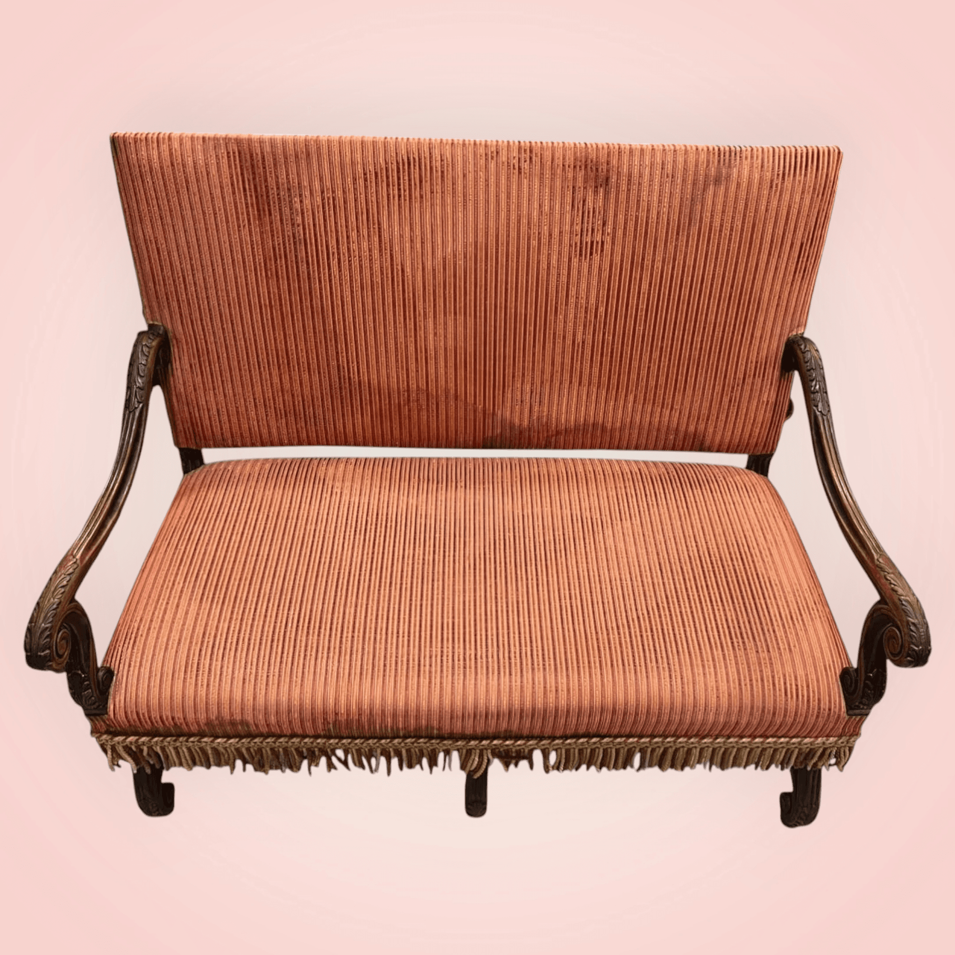 Sofá antiguo con respaldo alto, brazos curvos tallados y flecos decorativos. Perfecto para añadir un toque clásico a tu hogar.
