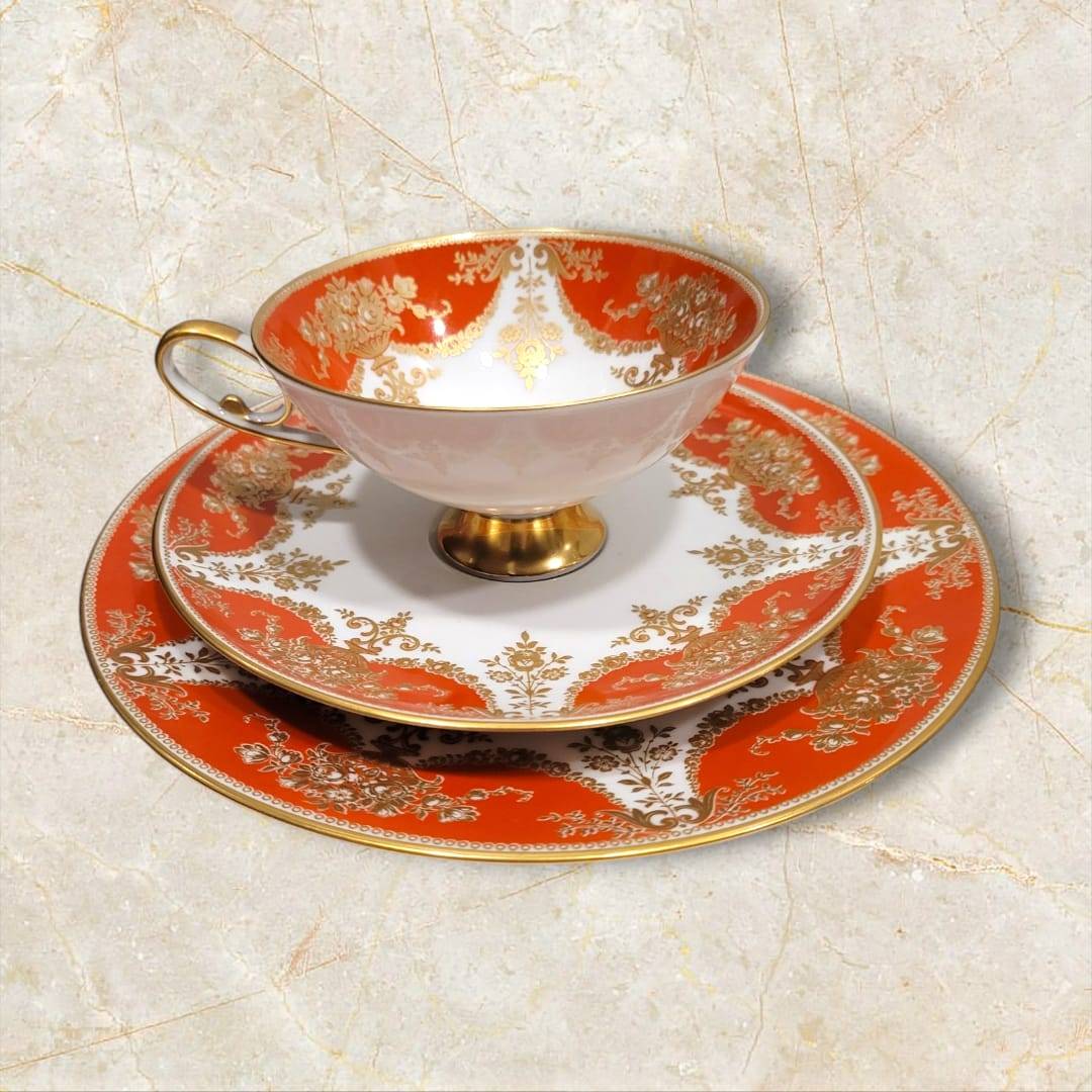 Detalle de taza y platos del exclusivo Tú y Yo de porcelana Alboth & Kaiser Bavaria, con elegante diseño rojo y dorado para decoración de interiores.