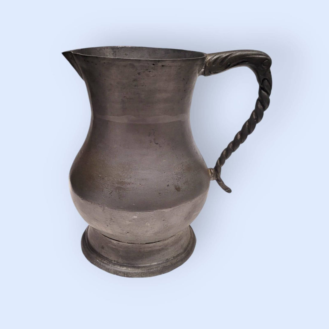 Jarra de peltre de estaño con diseño clásico y asa ornamentada, ideal para decoración vintage en hogar y jardín. Disponible en limbaproecher.com.
