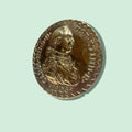 Decoración de bronce con busto de Carlos IV de Borbón en relieve, metopa o pisapapeles con acabado brillante y detalles históricos.