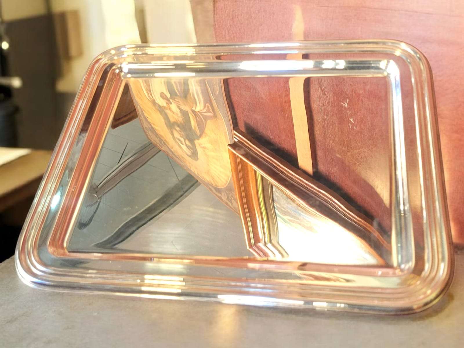 Bandeja decorativa de metal plateado con bordes ornamentales y gran brillo, ideal para regalar o ambientar espacios sofisticados.