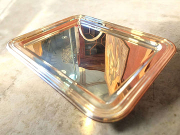 Bandeja de metal plateado con ornamentos elegantes y acabado pulido espejo, ideal para decoración de interiores en estilo clásico.