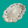 Bandeja decorativa de metal plateado con grabados ornamentales y bordes elegantes, ideal para estilo vintage.