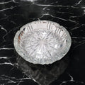 Vista superior de cenicero de cristal con relieves en forma de estrellas, pieza decorativa y práctica para interiores clásicos o modernos.