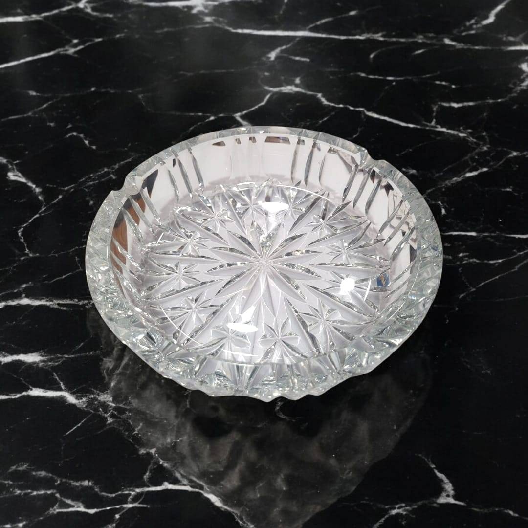 Vista superior de cenicero de cristal con relieves en forma de estrellas, pieza decorativa y práctica para interiores clásicos o modernos.