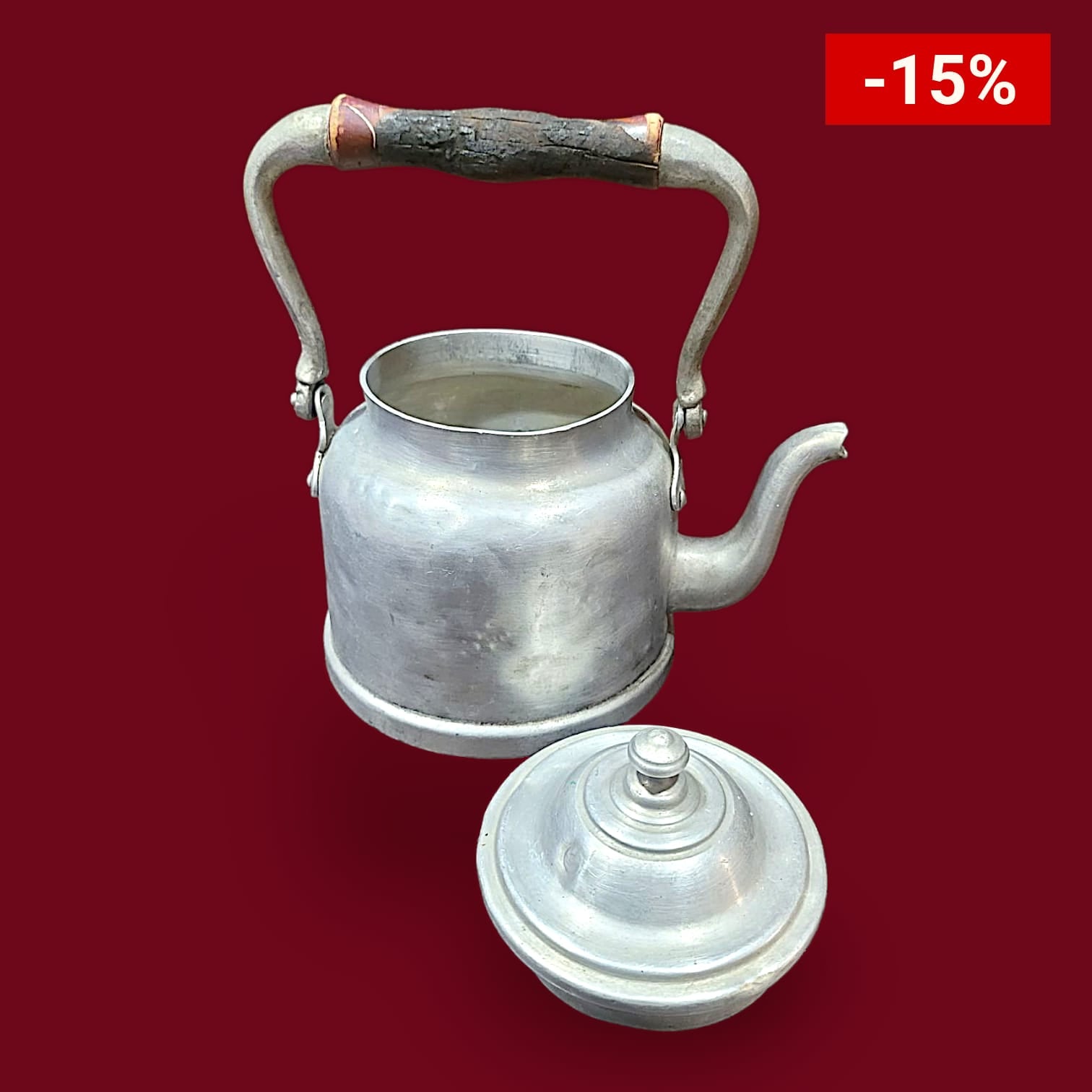 Cafetera de aluminio antigua con tapa removible y asa de madera. Diseño vintage ideal para decoración rústica y coleccionistas de piezas retro.