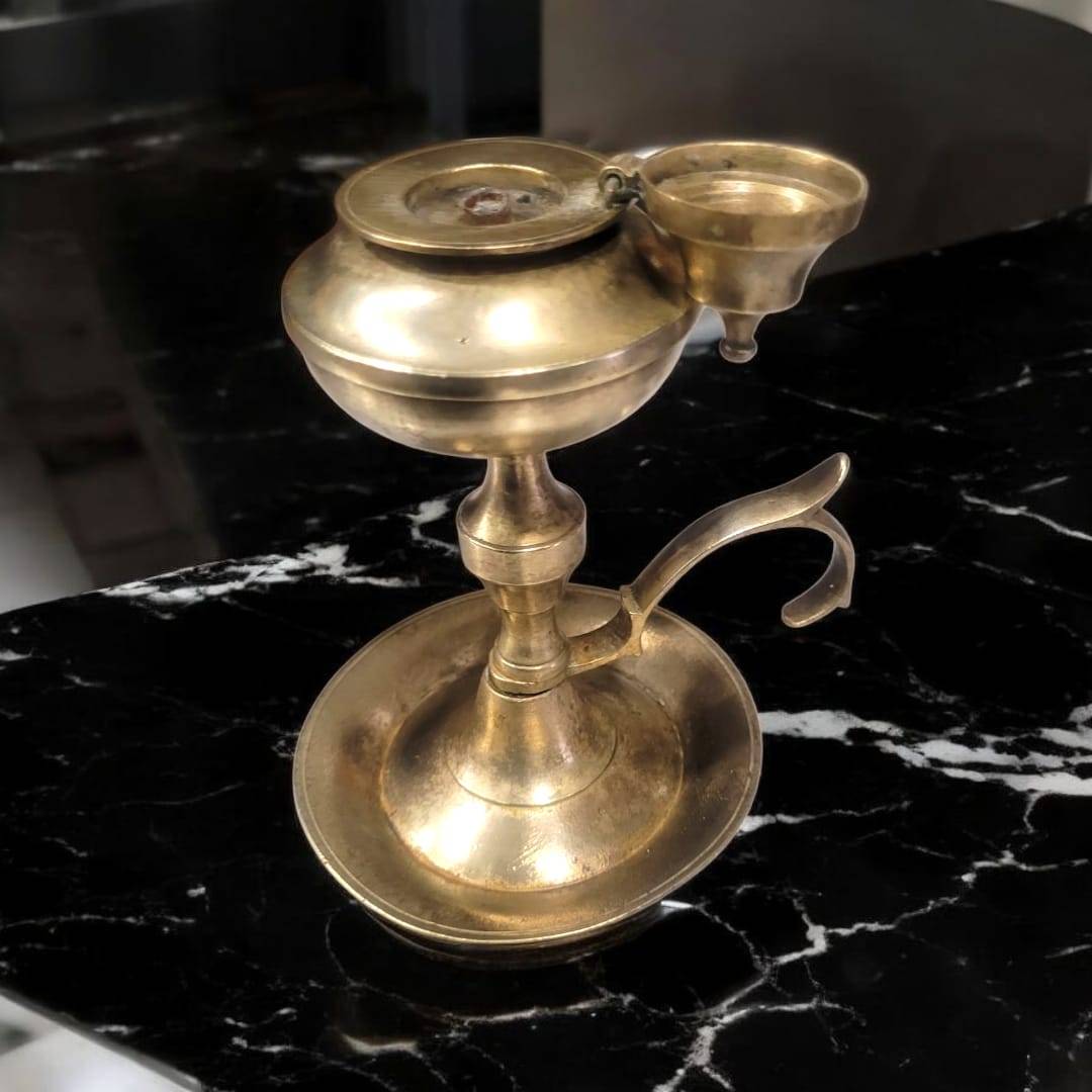 Candil de aceite antiguo con tapa funcional y quemador lateral. Pieza metálica dorada perfecta para ambientar espacios con estilo retro.