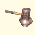 Chocolatera vintage de cobre mostrando su base ancha martillada