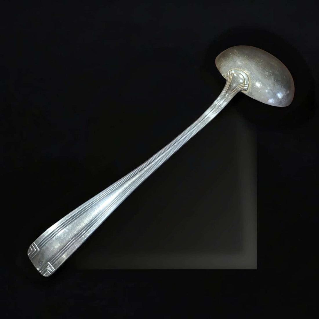 Cucharón antiguo de metal plateado elegante y funcional con mango decorado y diseño clásico, ideal para decoración vintage en cocina o comedor.