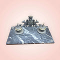 Escribanía con base en mármol negro y escudo imperial frontal.