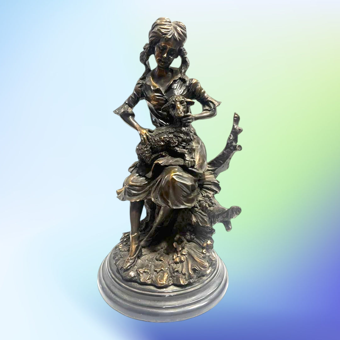 Figura decorativa de resina con acabado antiguo que muestra a una niña sentada con una oveja en brazos. Ideal para decoración clásica y encantadora.