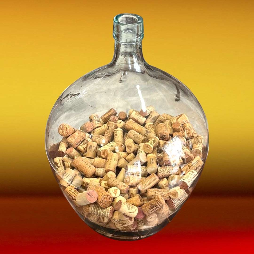 DamaJuana antigua de cristal soplado con corchos en su interior, perfecta para ambientar espacios de estilo vintage o bodegas.