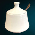 Azucarero en porcelana blanca con diseño elegante y acabado brillante, ideal para complementar espacios de decoración en hogar y cocina.