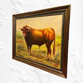 Cuadro óleo taurino con toro castaño en campo, obra de Juan Lara. Decoración artística para el hogar con marco clásico y detalles vibrantes.