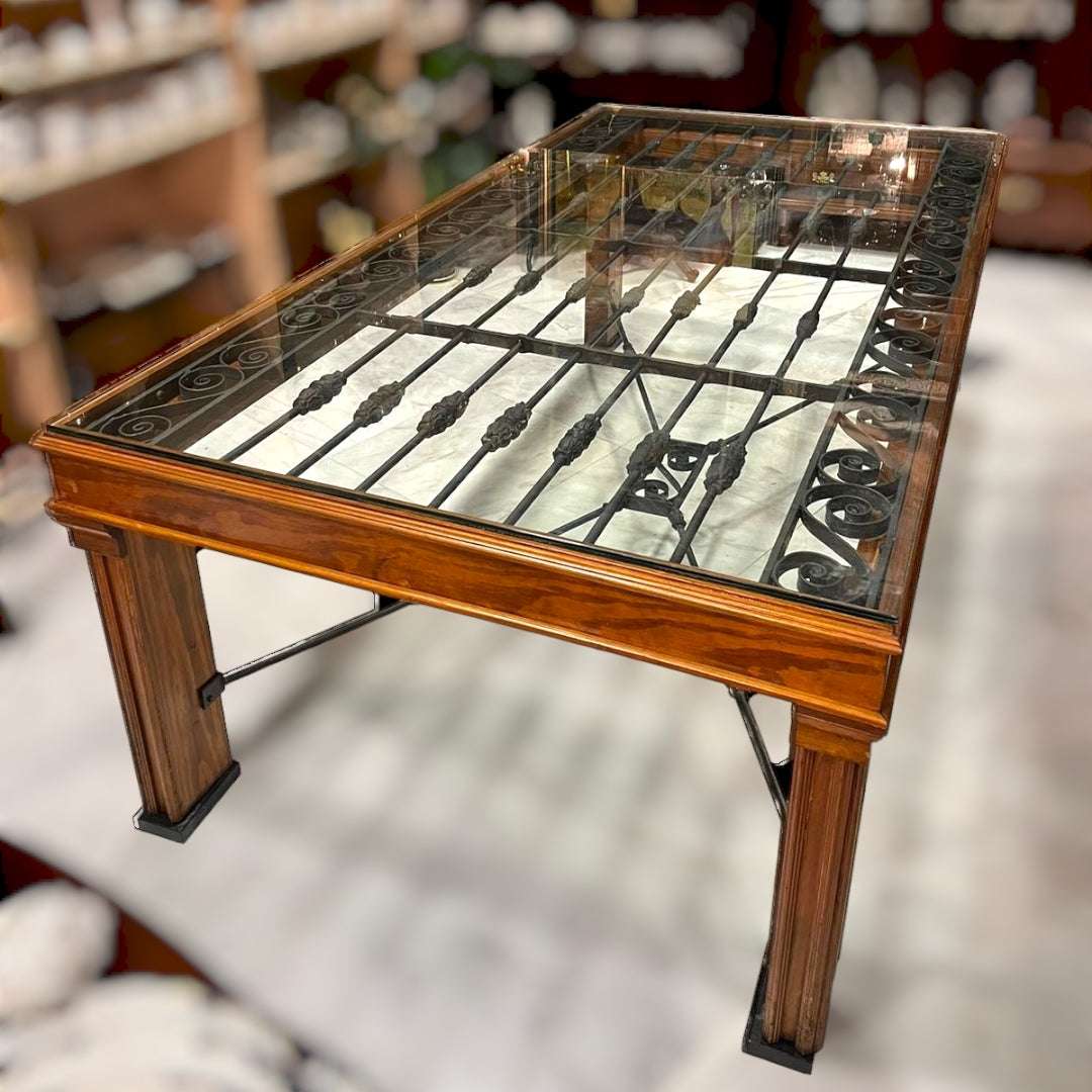 Mesa Reja Comedor con diseño artístico en hierro bajo cristal, estructura robusta de madera, ideal para decoración de comedor con estilo industrial.