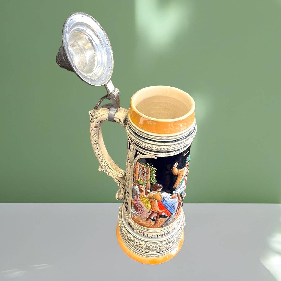 Jarra de Cerveza Praga abierta, mostrando interior de porcelana y tapa metálica articulada, pieza decorativa ideal para coleccionistas de cerámica alemana.