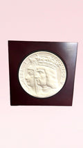 Medallón V Centenario Lladro con retrato en relieve de los Reyes Católicos, Isabel y Fernando. Pieza de porcelana en base de madera, edición limitada.