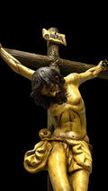 Detalle de crucifijo de terracota con Cristo en cruz de madera. Ideal para decoración espiritual en interiores con estilo clásico.