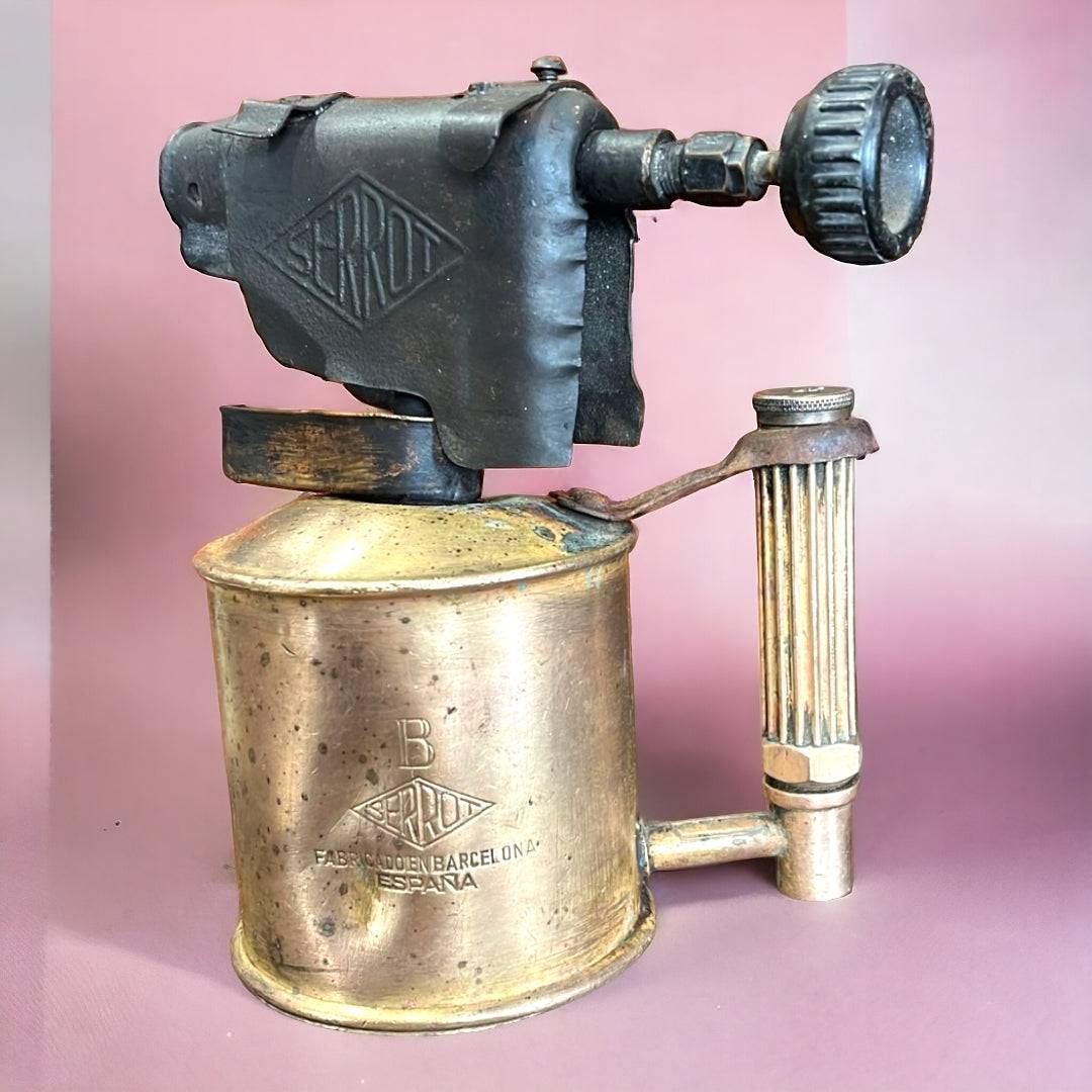 Soplete antiguo de fontanero marca Serrot fabricado en Barcelona, ideal para decoración vintage en espacios de hogar y jardín.