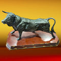 Figura decorativa de toro en resina policromada, vista lateral. Ideal para añadir fuerza y elegancia a espacios del hogar o jardín.