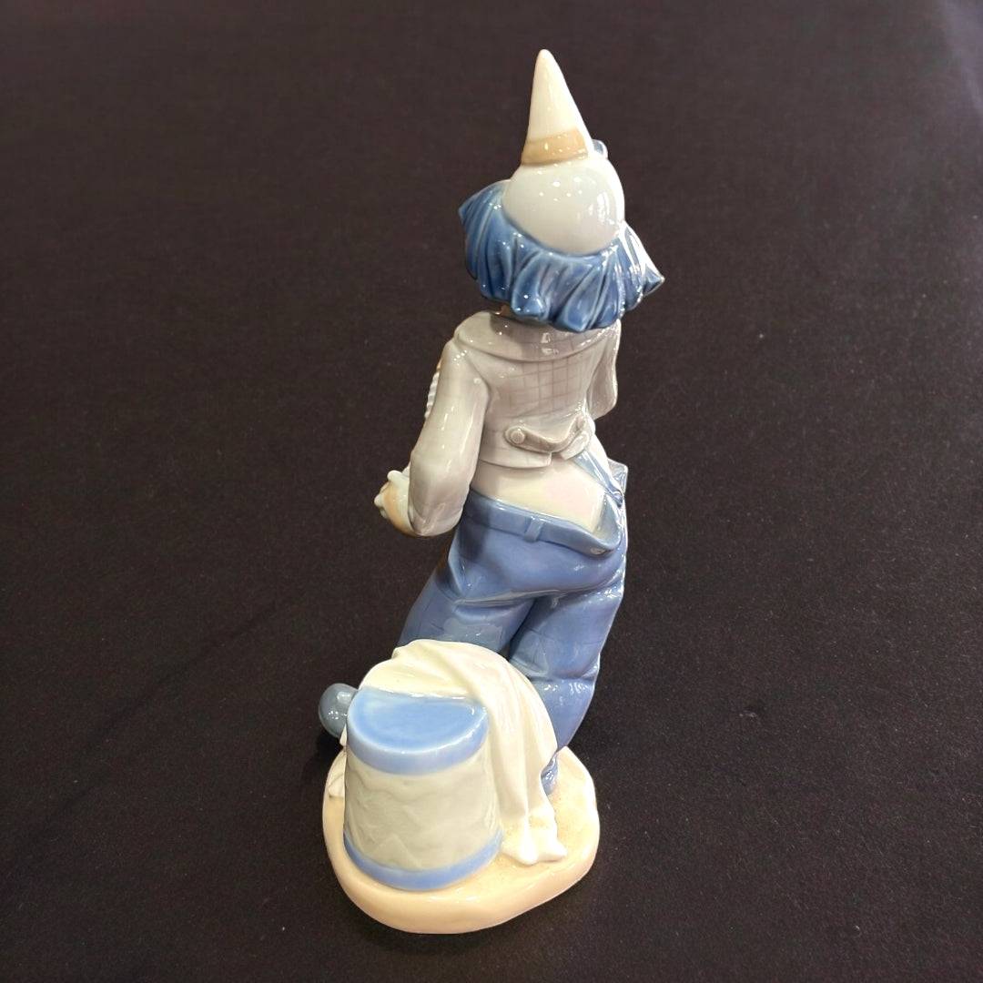 Vista trasera de figura Nao-Lladró de payaso con acordeón, mostrando detalles en porcelana esmaltada y acabado artesanal.