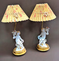 Pareja de lámparas de noche con querubines de porcelana y pantallas plisadas con diseño floral, ideales para decoración vintage.