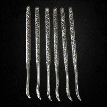 Juego de seis palillos antiguos en metal plateado para caracoles o mariscos, con mango decorativo grabado. Ideal para decoración vintage.