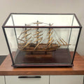 Maqueta del Cutty Sark exhibida en vitrina de vidrio sobre encimera. Pieza histórica perfecta para coleccionistas y decoración vintage.