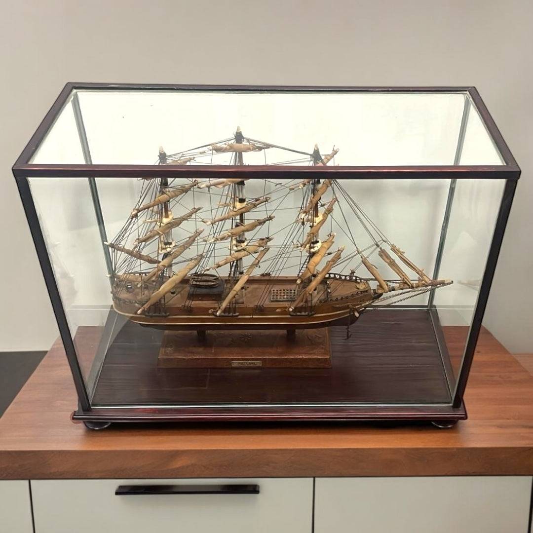 Maqueta del Cutty Sark exhibida en vitrina de vidrio sobre encimera. Pieza histórica perfecta para coleccionistas y decoración vintage.