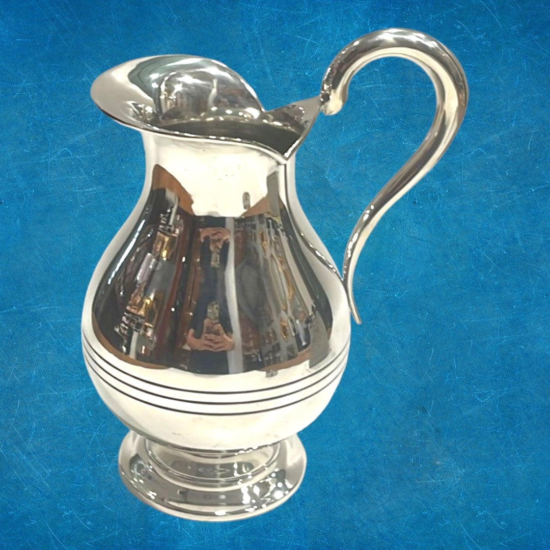 Jarra decorativa de metal plateado con diseño moderno y líneas estilizadas, perfecta para complementar espacios contemporáneos.