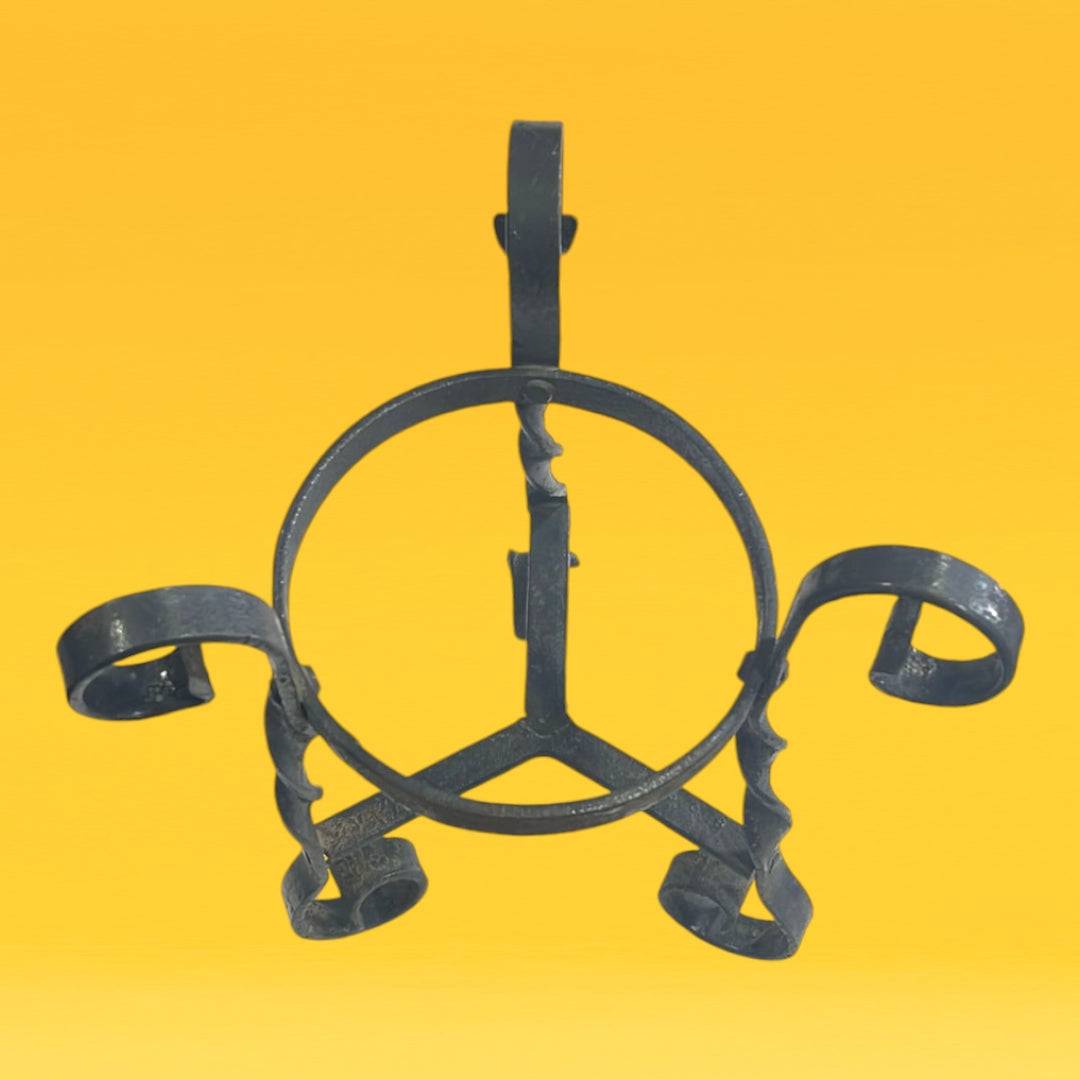 Soporte de maceta en hierro forjado con acabado artesanal, ideal para decorar espacios con estilo rústico y elegante.