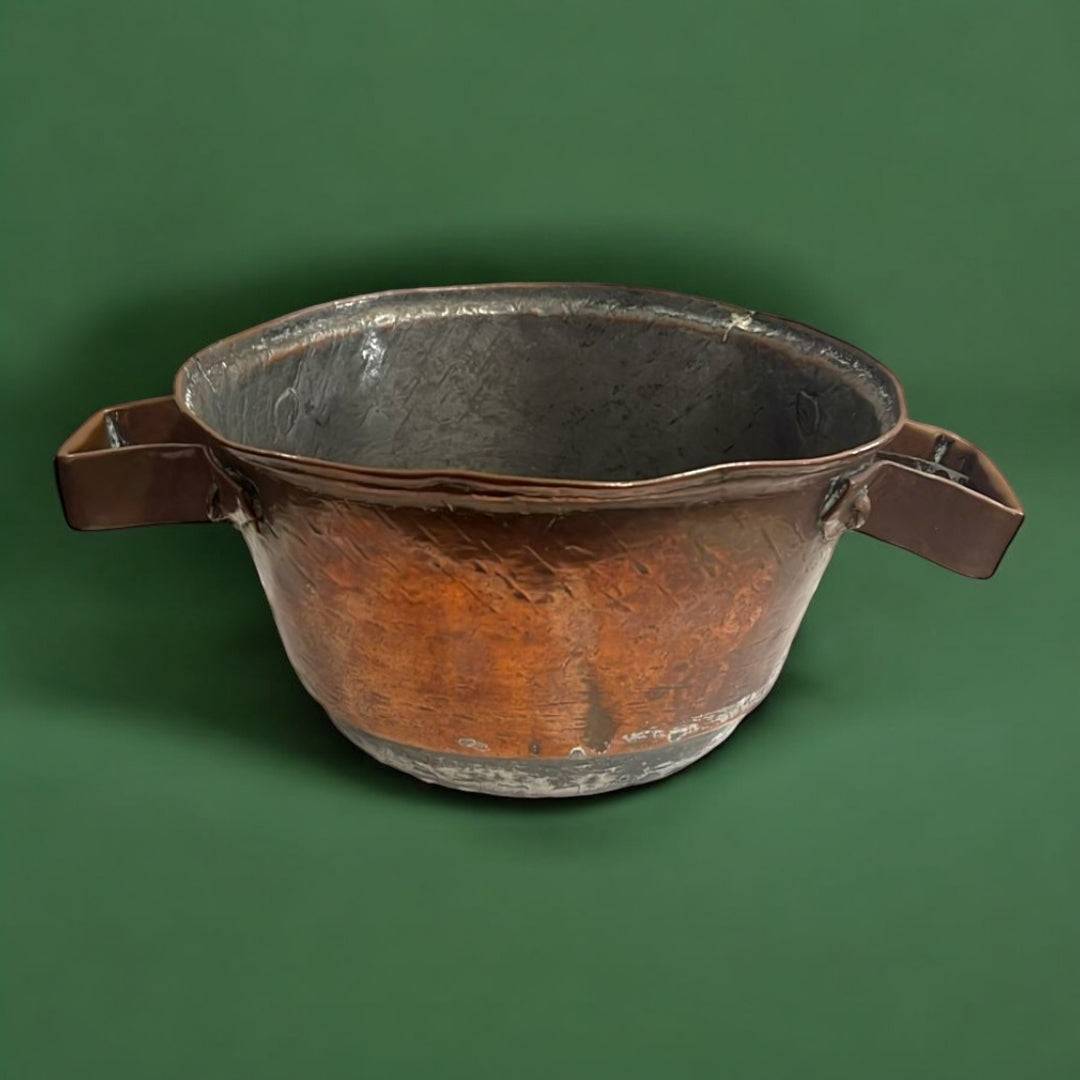 Cocedero de cobre antiguo con forma ancha y asas laterales, pieza decorativa vintage para ambientes de estilo rústico en hogar y jardín.